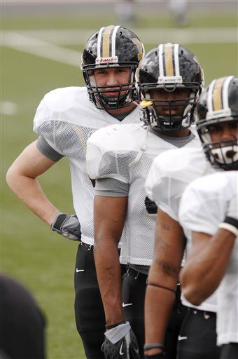 FILE - In this March 21, 2007, file photo, then-Missouri redshirt freshman Michael Keck, left, listens to a coach during defensive drllls at Faurot Field in Columbia, Mo. Keck, who transferred to Missouri State in 2009, played just two years of college football before he was knocked out and gave the sport up for good. He turned combative, began to struggle in school, and soon was spending most of his time indoors in a darkened room. Keck died in 2013 at age 25 of what doctors believe was an unrelated heart condition. His brain, as he requested, was donated to the Boston University lab researching a degenerative brain condition frequently found in contact-sport athletes. It was found that Keck had chronic traumatic encephalopathy, which had advanced to a stage never before seen in someone so young. (AP Photo/L.G. Patterson, File)